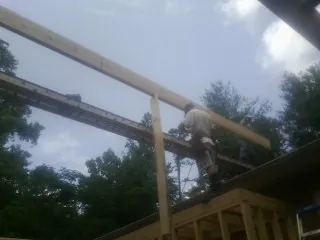 Carpenter setting a ridge beam over a new addition frame — Ice Dam Removal by Roofing Brothers in Telford