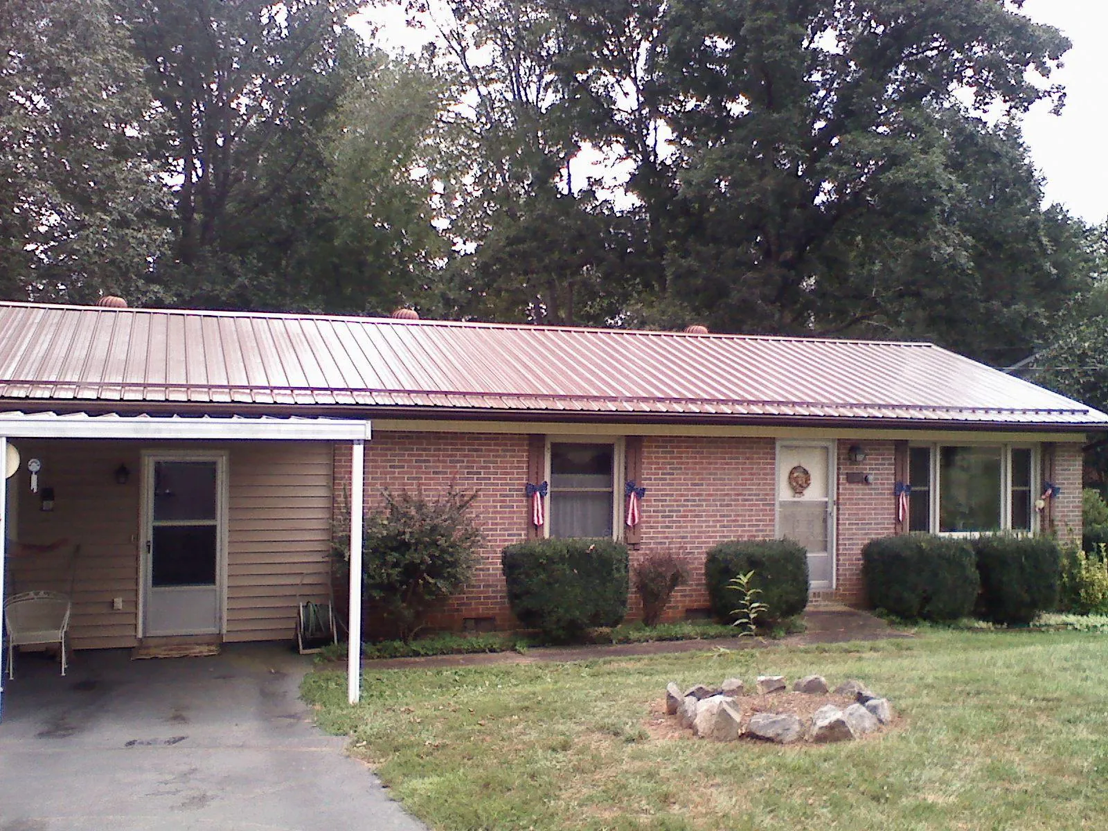 Bronze metal roof and carport on a brick ranch home — Roof Repair work by our crew in Telford